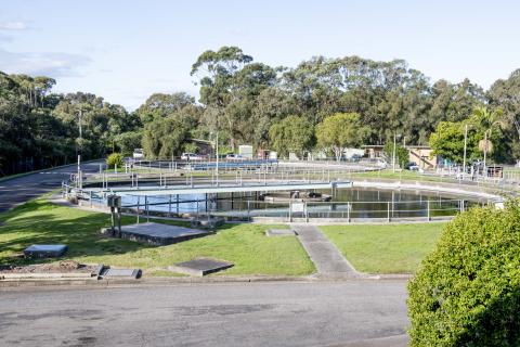 Image of two round lagoons with green grass and concrete pathways to fencing around lagoon