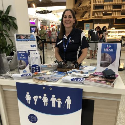 woman at shopping centre desk with brochures