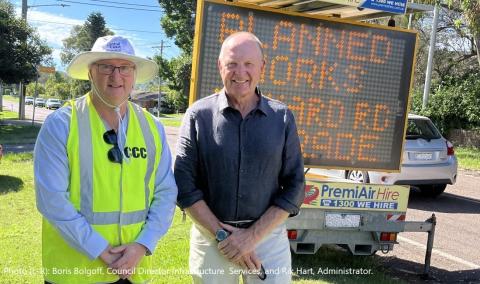 men in front of digital road sign 