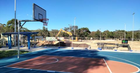 basketball court in foreground with construction in background