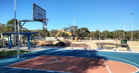 basketball court with skate park construction basketball court in foreground with construction in background