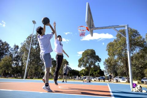 Two teenage boys playing basketball Two teenagers playing basketball on a court