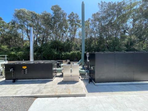Bateau Bay Sewage Treatment plant upgrade A large industrial facility featuring two prominent black tanks against a clear sky backdrop.