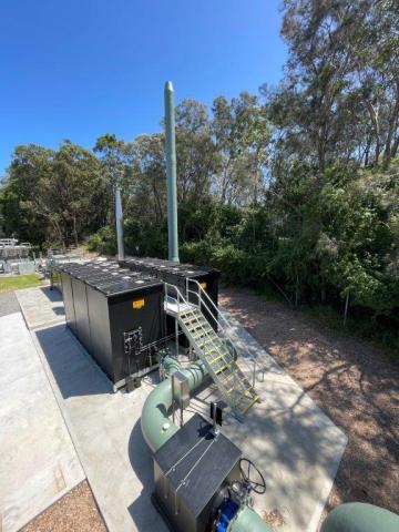 Bateau Bay Sewage Treatment plant upgrade A large industrial building featuring extensive piping and a prominent, oversized pipe structure.