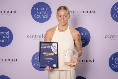 Matilda Taylor (Young Person Award) woman standing in front of screen holding an award