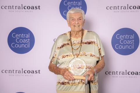 Betty Brown (Senior Citizen Award) woman standing in front of screen holding an award