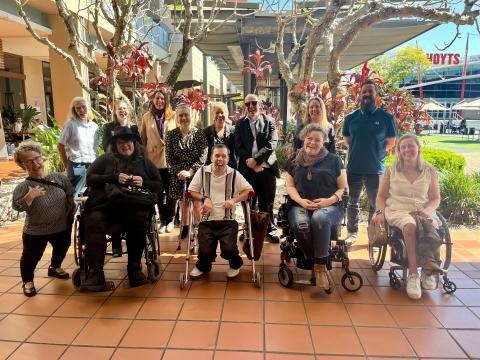 Access and Inclusion Reference Group Group of people outside on tiled pathway with tree in background and shopping centre forecourt
