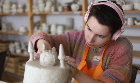 girl with headphones on making a pottery sculpture girl with headphones on making a pottery sculpture